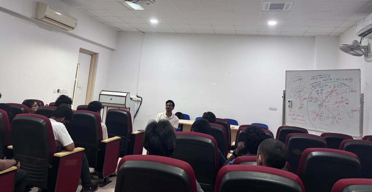 A speaker in conversation with students in a college classroom